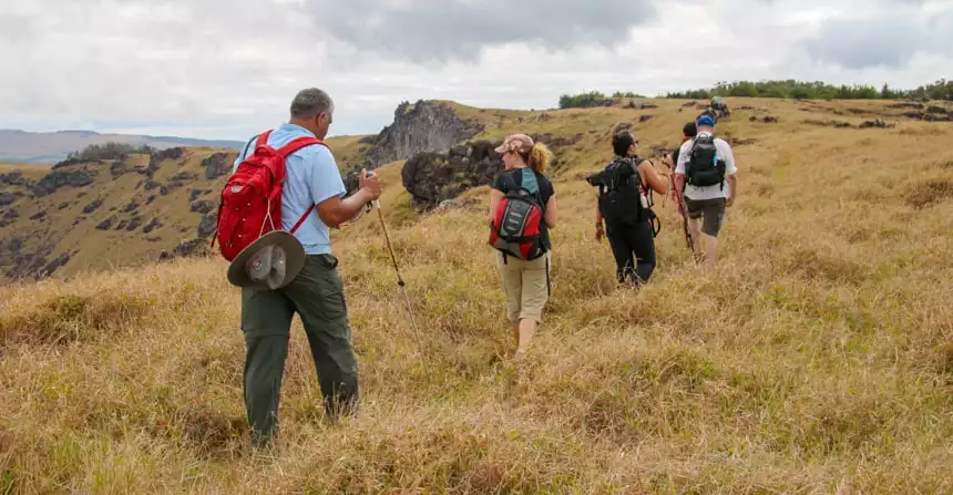 A group of travlers walk in a meadow on Easter Island while staying at Explora Rapa Nui Lodge