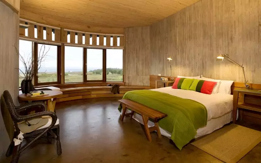 a suite inside Explora Rapa Nui Lodge, natural earth tones used throughout a circular room with tall windows and a seating area