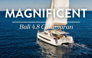 Belize charter yacht Magnificent, a 48-foot while catamaran, cruises in calm water with both sails fully open.