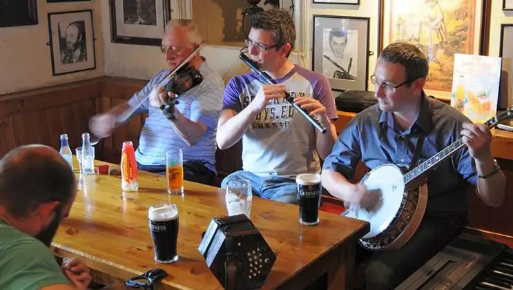 4 men play traditional Irish music in a pub during the Classic Ireland River Cruise.