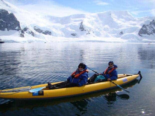 Couple kayaking in Antarctica from their small ship cruise. 