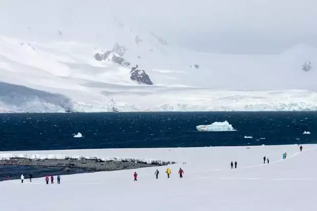 Small cruise ship hiking excursion on the snow in Antarctica. 