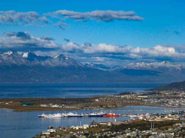 Ushuaia seen from a view point with the harbor and mountains in the background.
