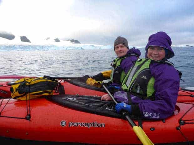 Two guests from a small ship cruise on a kayaking excursion in Antarctica. 