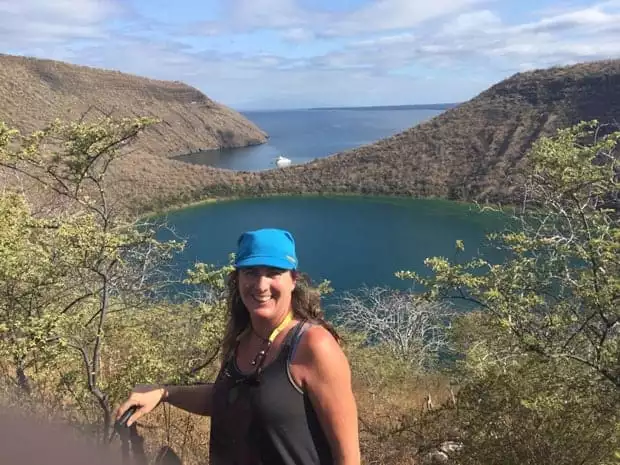 Happy guest from a small ship cruise  at a viewpoint on a hiking tour in the Galapagos. 