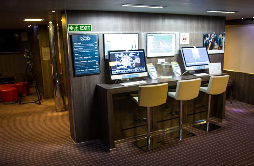 The media center aboard L'Austral luxury ship, three bar height chairs are seated in front of computer screens,