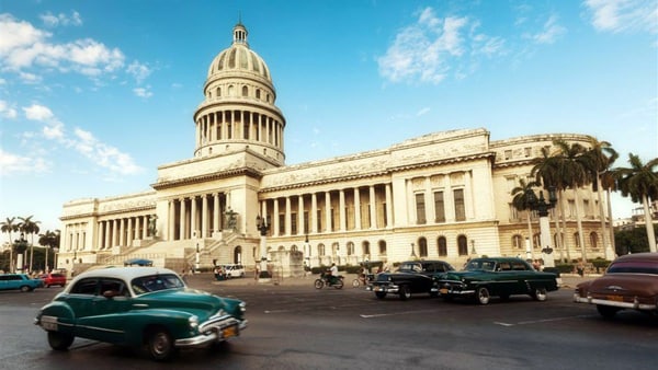 building in Havana Cuba with old cars in front of it