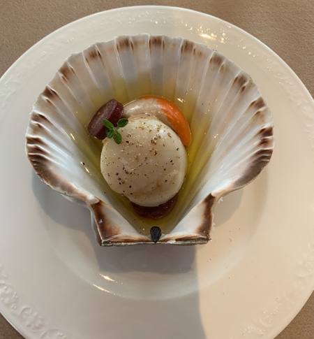 A dinner plate served aboard the Classic Scotland Barge Cruise, the meal sits inside an enlarged plate that looks like a sea shell.