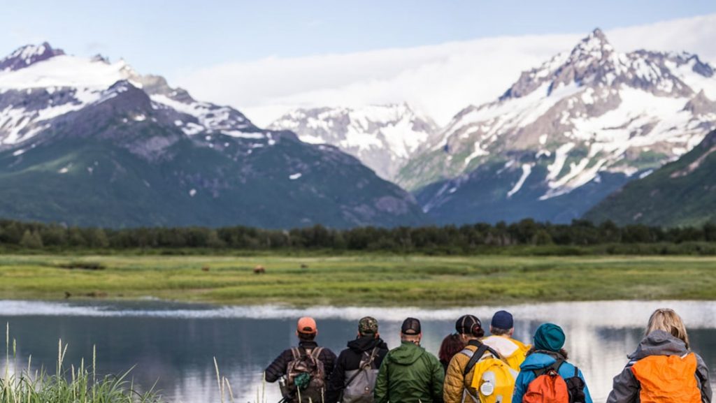 Travelers practice their Alaska cruise photography with bears roaming on the other side of calm water during the Alaska Bear Country & Wilderness Expedition.