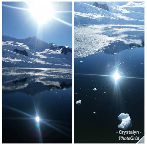 Sun with blue sky reflection in the calm icy waters of Antarctica seen from a small cruise ship.