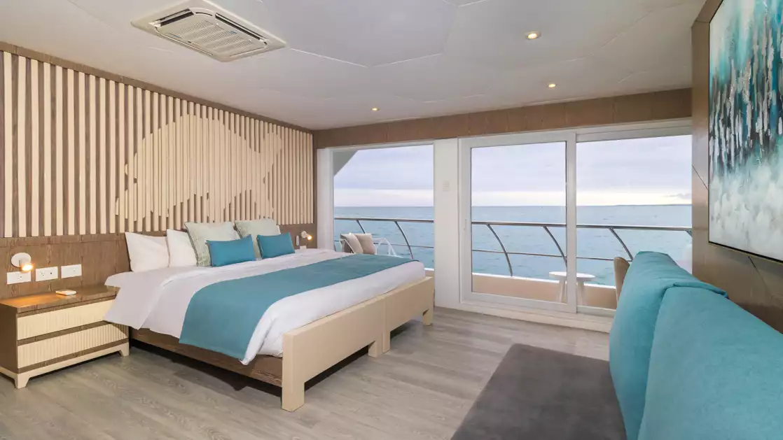 A comfortable king sized bed with stunning views from your balcony enjoying the beauty of the Galapagos while aboard the Elite