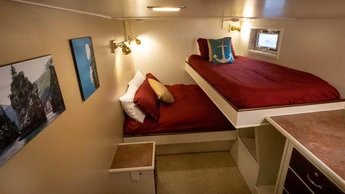 the Kittiwake cabin features a couple portholes a full bed and a twin with artwork on this cruise aboard the Sea Star