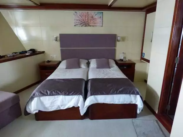 Stateroom on the small motor yacht Futura with 2 twin beds put together and nightstands.