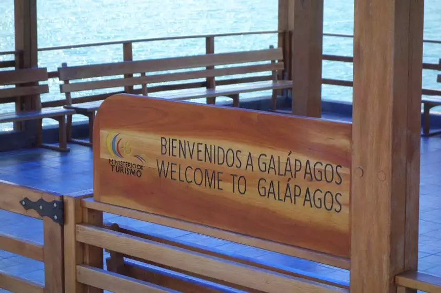 Close up of a wooden sign that says in both English and Spanish Welcome to Galapagos