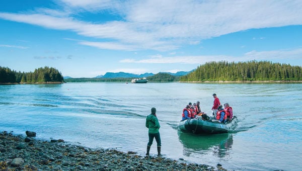 A group of adventure travelers coming ashore on a British Columbia cruise in the pacific northwest.