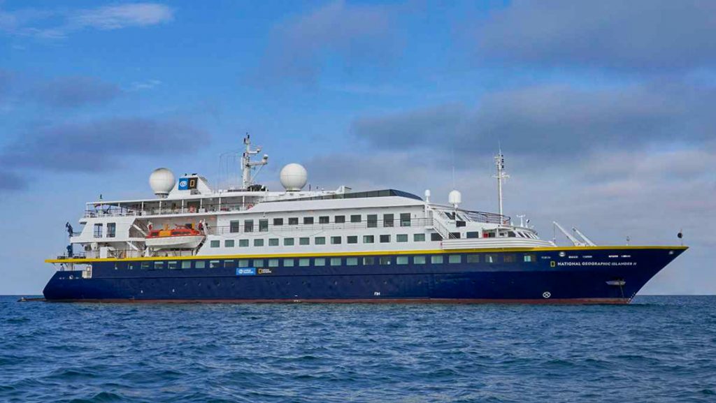 National Geographic Islander II Galapagos luxury expedition ship, with dark blue hull, white upper decks & Ecuador flag.