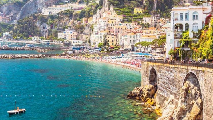 Seaside town of Amalfi, Italy with turquoise water below cliffside stone buildings seen on a western Mediterranean cruise.