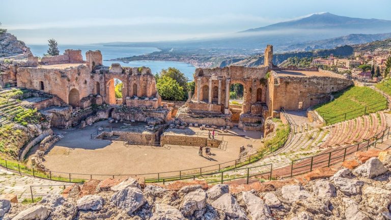 Ancient outdoor Greek theater in Sicily, Italy, with circular rows looking out over the ocean, seen on a western Mediterranean cruise.