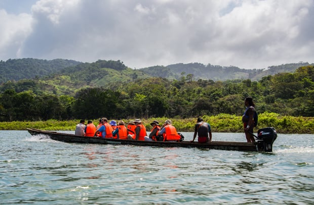 Group of costa rica travelers motoring in a dugout canoe on the Mogue River in Panama.