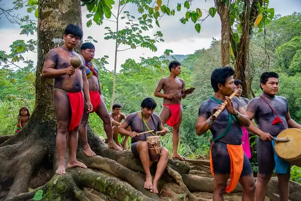 Embera people in traditional clothing playing traditional instruments in the costa rica jungle