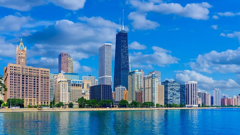 Downtown Chicago with tall dark Willis tower seen from the waterfront on a calm day during small ship great lakes cruises.