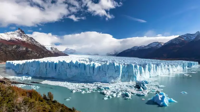 Massive diamond-shaped glacier of white & blue tumbles into a turquoise lake of glacial silt, seen on Explora El Chaltén.