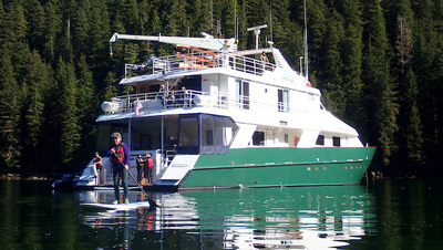 UnCruise reviews Safari Quest small ship in Alaska with painted green hull and white upper decks. 