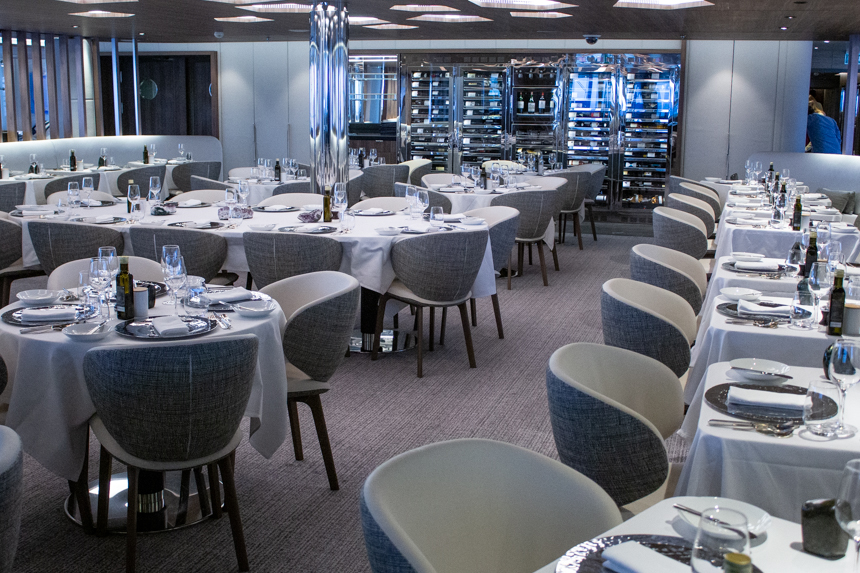 Michelin star restaurant Nuna aboard Charcot ship, grey and white fabric chairs around tables with white tables cloths. 