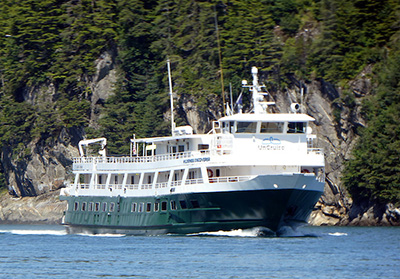 UnCruise reviews 76-guest Wilderness Discoverer in Alaska with painted green hull and white upper decks. 