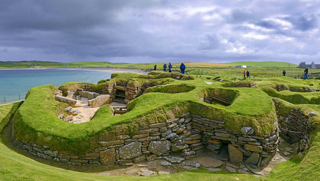 Bright green grass tops ancient stonework dwellings at Skara Brae in the Orkneys Scotland
