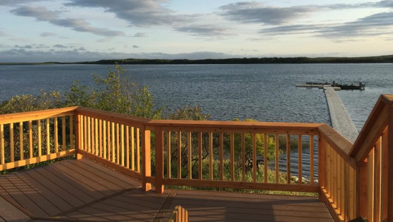 Modern deck overlooking large Naknek River under a cloudy sky, used as a viewing platform for King Salmon Alaska lodging.