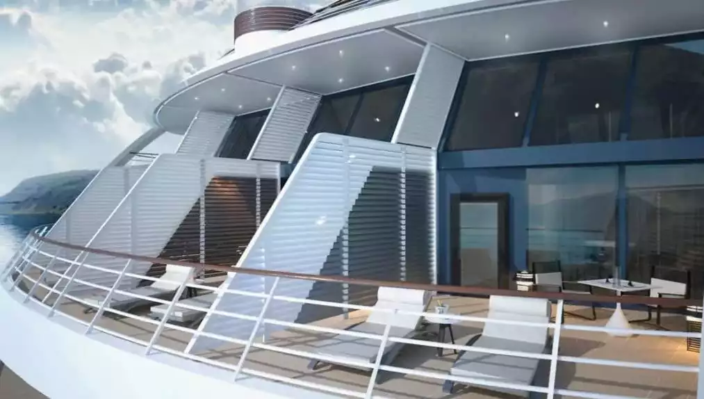 A two-story suite on an Antarctica luxury ship seen from the exterior with lounge chairs and tall glass windows 