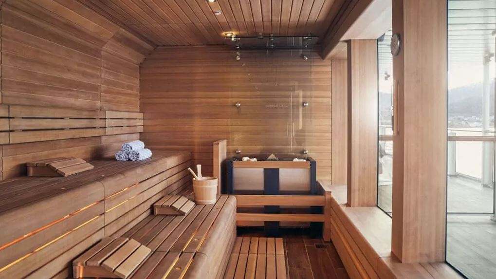 A sauna with floor to ceiling wood and big glass windows on one side seen aboard a luxury Antarctica cruise ship