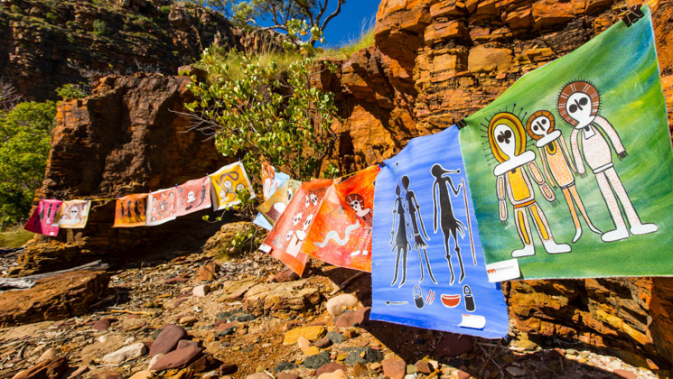 Modern multicolored Wndjina aboriginal art strung across red canyon rock at Raft Point in Northwest Australia's Kimberley Region.