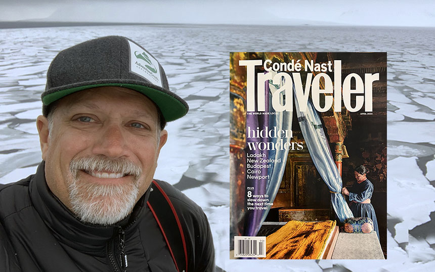 AdventureSmith Explorations founder Todd Smith poses in a grey AdventureSmith hat in front of a sea of Arctic ice, with the Conde Nast Traveler April cover over the image