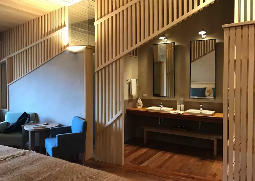 Standard room at Explora Sacred Valley with bathroom sink area with double sinks and mirrors, enclosed with wooden slats.