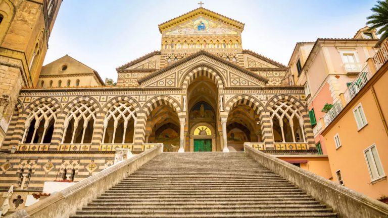 Amalfi building with stone exterior & steps, arches & cathedral-like windows seen on a southern Italy & coastal Croatia cruise.