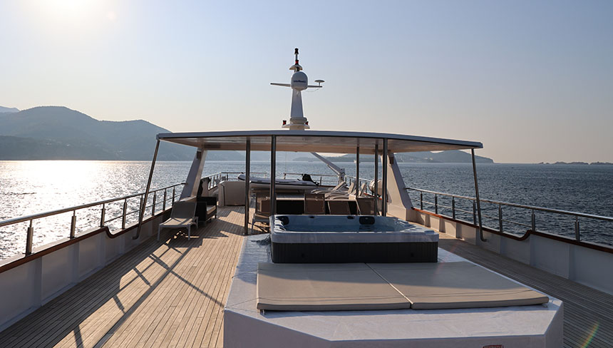 The top deck of the Aurora yacht seen with lounge chairs and hot tub