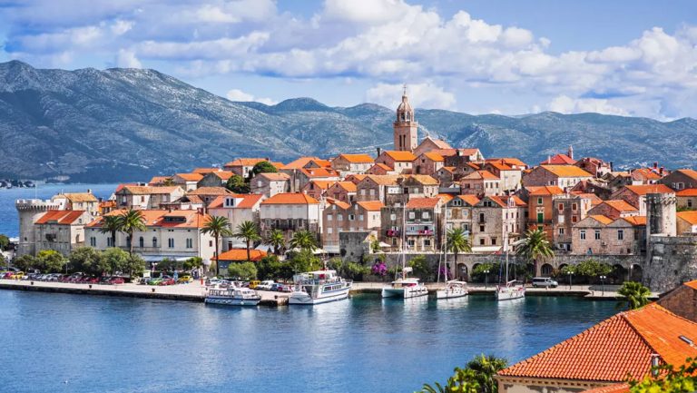 Korcula Island with stone homes & terracotta roofs on a small hill topped by a bell tower, seen on a cruise to Croatia & Italy.