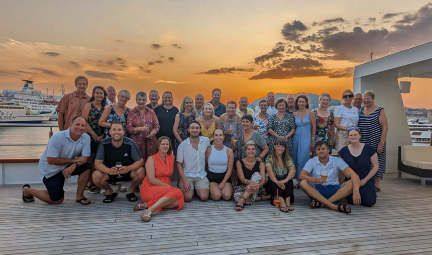 Group photo showing the passengers aboard the Aurora yacht's top deck at sunset in Split Croatia