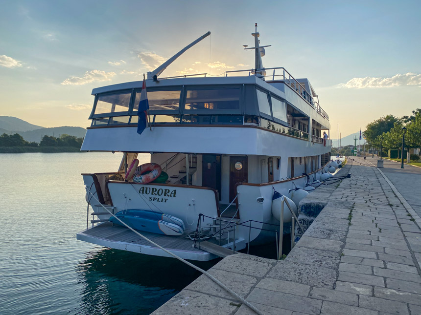 The Aurora yacht seen docked by a stone sidewalk in Opuzen Croatia at sunset