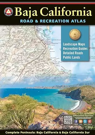 Book cover of Baja Road and Recreation Atlas with tan title text over black background above a sample of a map over a photograph of a blue water cover surrounded by green desert landscape and a green cactus.  