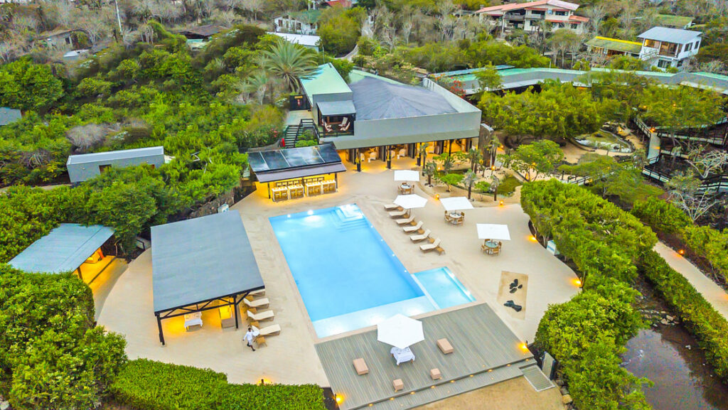 Aerial view of Finch Bay Galapagos hotel with pool, expansive decks & walkways, green gardens & interconnected buildings.