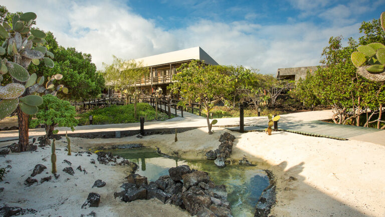 Walkways surrounded by cacti and trees around the exterior of Finch Bay Eco Hotel in the Galapagos Islands