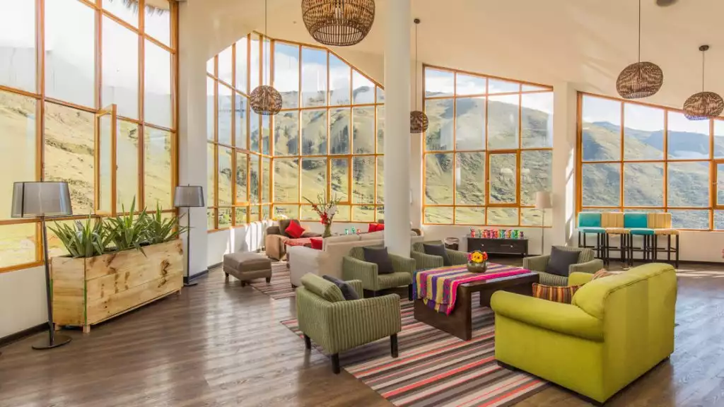 Lounge of Huacahuasi Lodge with breathtaking views through the large windows and an updated look