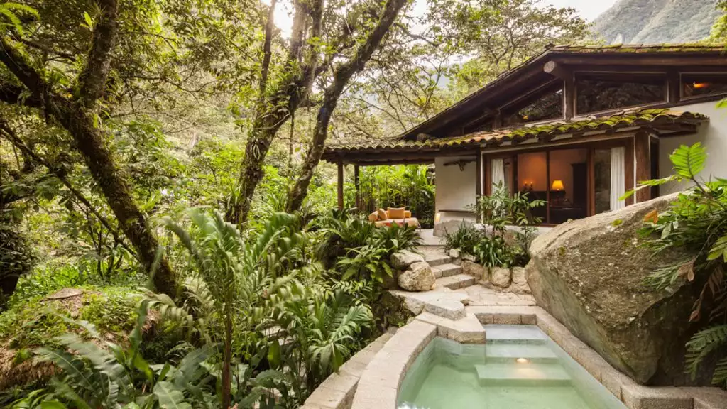 Hotel villa with large overhanging trees, stairs down to private pool, an outdoor