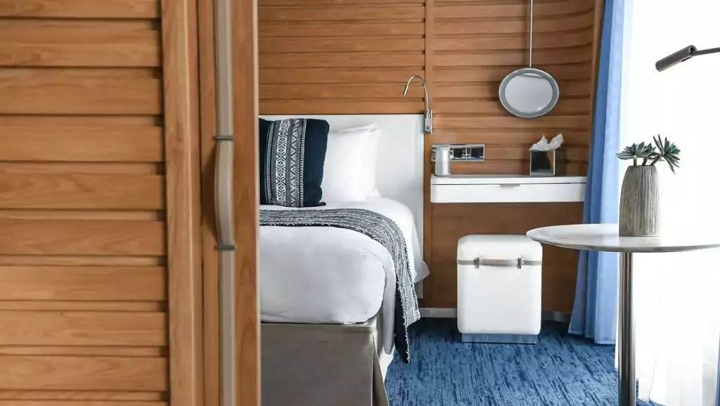 Prestige Suite bedroom with king bed aboard Le Laperouse. Photo by: Ponant