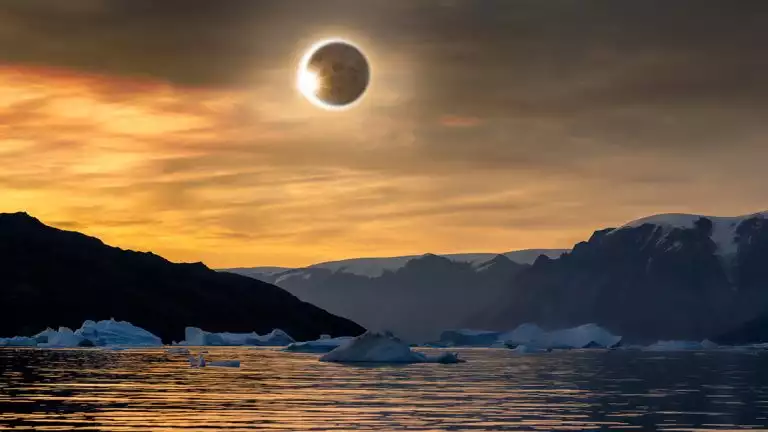 Solar eclipse reflects over cold icy waters with icebergs and dark rocky mountains.