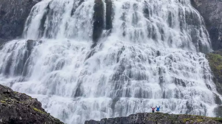 Lindblad Expeditions guests standing at Dynjandi waterfall, also known as Fjallfoss, Westfjords of Iceland.