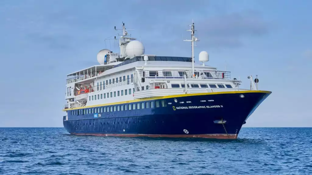 National Geographic Islander II Galapagos luxury expedition ship, with dark blue hull, white upper decks & Ecuador flag.